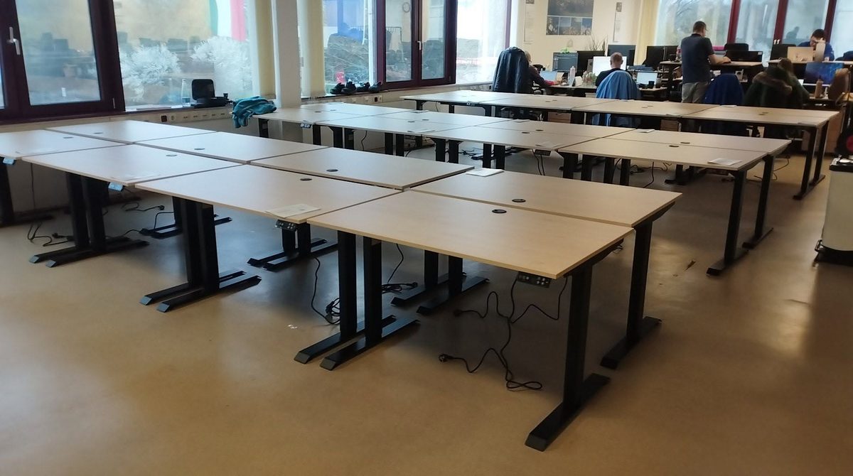 Elektromosan állítható asztalokkal berendezett nagy irodai munkatér